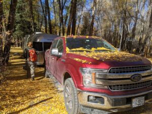 truck and airstream in Telluride covered in aspen leaves