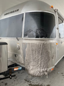 the Airstream covered in road snow